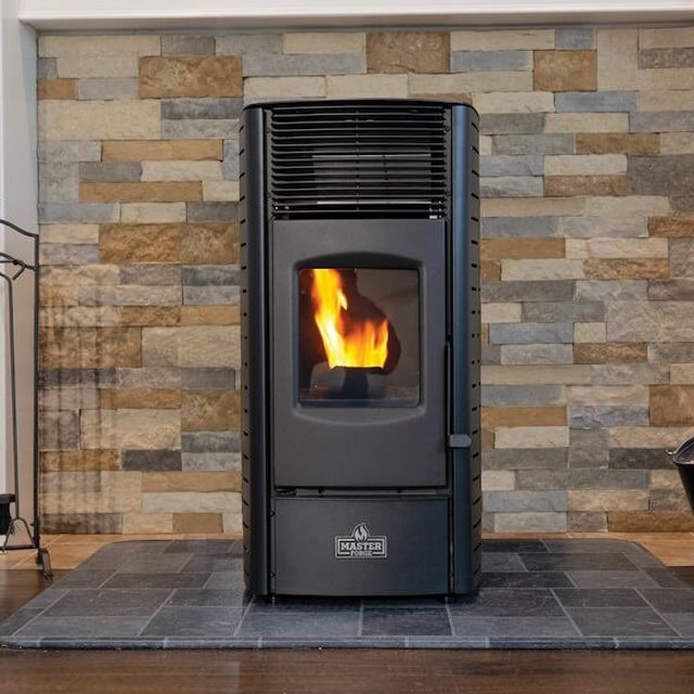 Matte black pellet stove in front of a brick wall