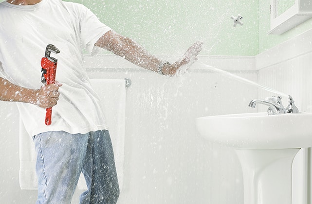 Man being sprayed by a bathroom faucet Man being sprayed by a bathroom faucet