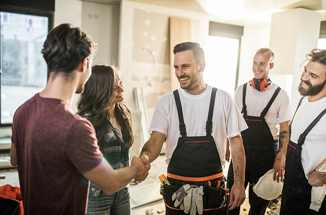 Couple shaking hands with three contractors Couple shaking hands with three contractors