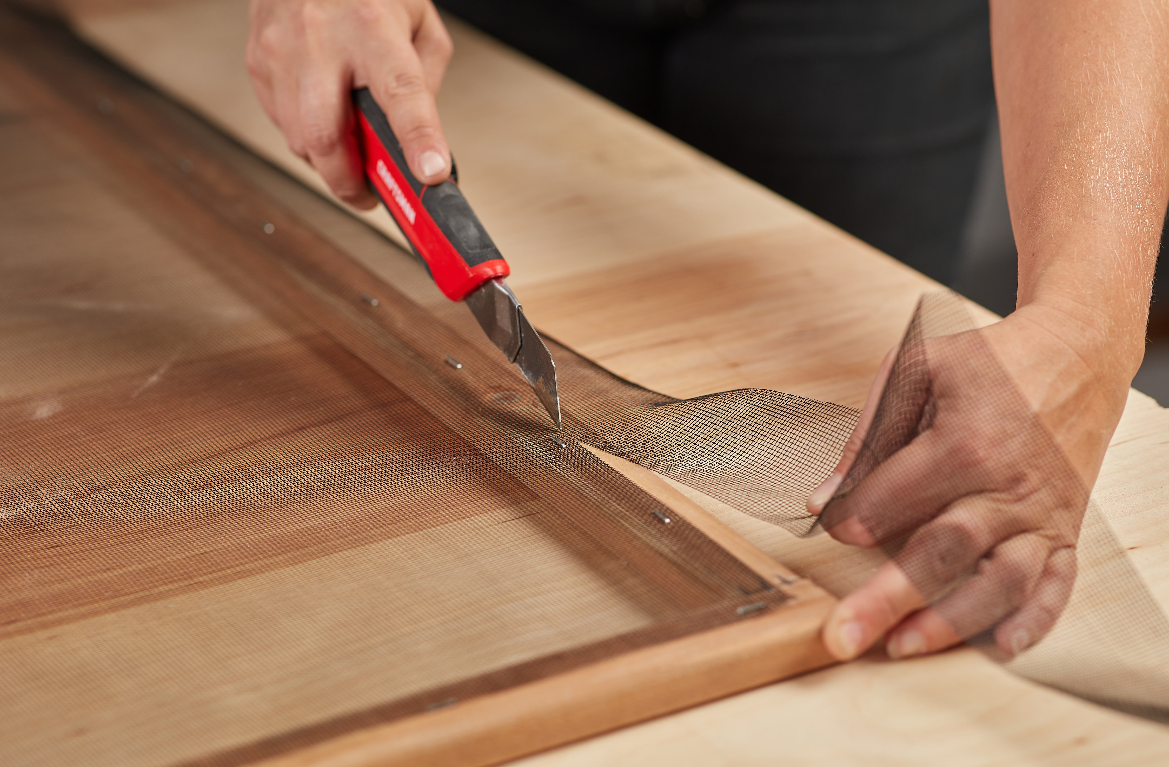 Personne utilisant un couteau à lame rétractable Personne utilisant un couteau à lame rétractable