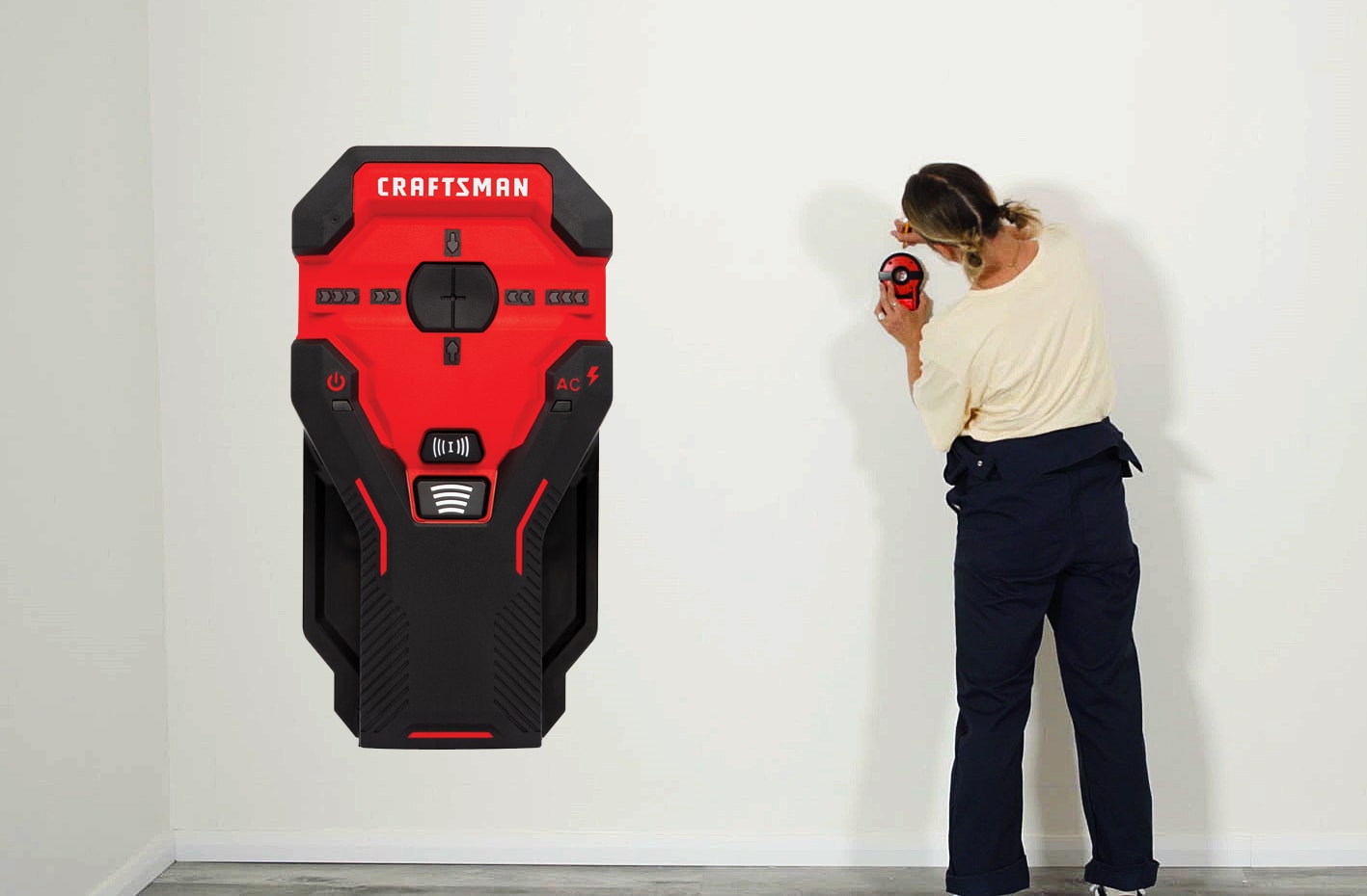 Woman using a stud finder Woman using a stud finder