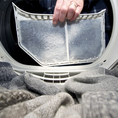 Person cleaning a dryer lint filter Person cleaning a dryer lint filter
