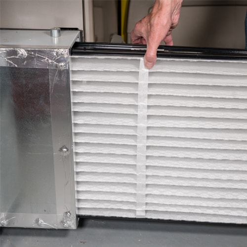Person removing a filter from a heating system