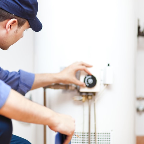 Person maintaining a hot water heater Person maintaining a hot water heater