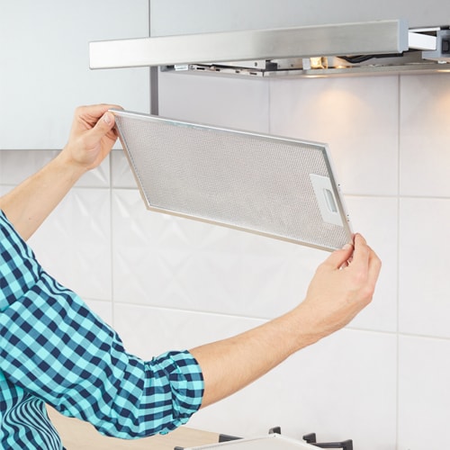 Person removing the filter from a range hood