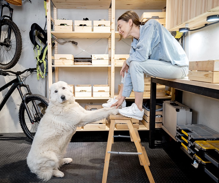 Young woman with her dog in a garage Young woman with her dog in a garage