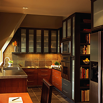 Kitchen with stainless steel counters and glass- fronted cabinets