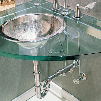 Stainless steel bathroom sink installed on a glass countertop