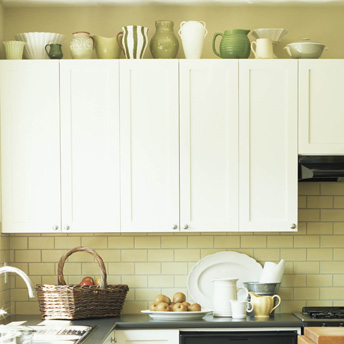 Decorative containers on wall cabinets provide extra storage